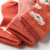 Close-up of Happy Koala baby socks in terracotta tones with embroidered patterns